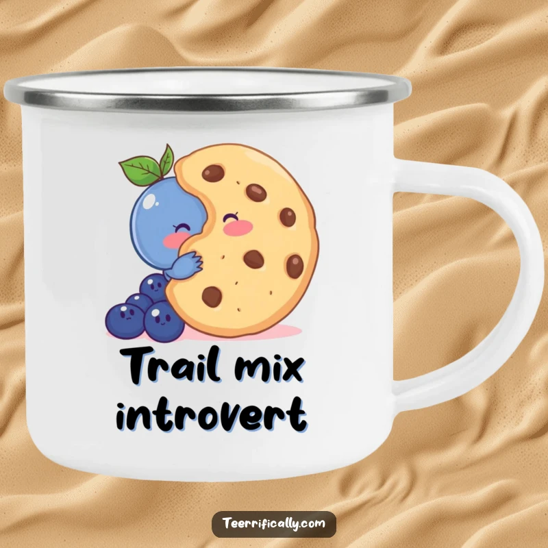 Funny enamel camping mug showing a shy blueberry blushing behind a giant cookie, ideal for cute outdoor enjoyment.