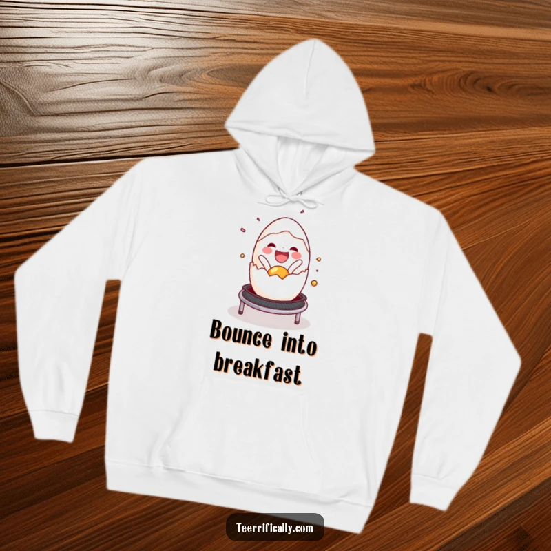 Funny cracked egg hoodie, joyfully spilling onto a trampoline, radiating happiness and a playful vibe. Cozy and humorous.