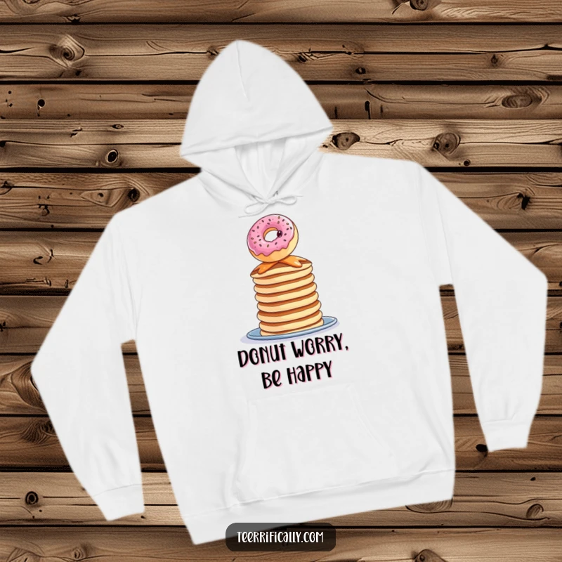 Funny donut pancake hoodie, a curious donut balancing precariously on pancakes, cozy and whimsical.