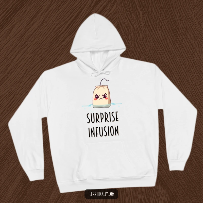 Funny Hoodie depicting a grumpy teabag with wide, surprised eyes as it floats to the surface, a humorous visual.