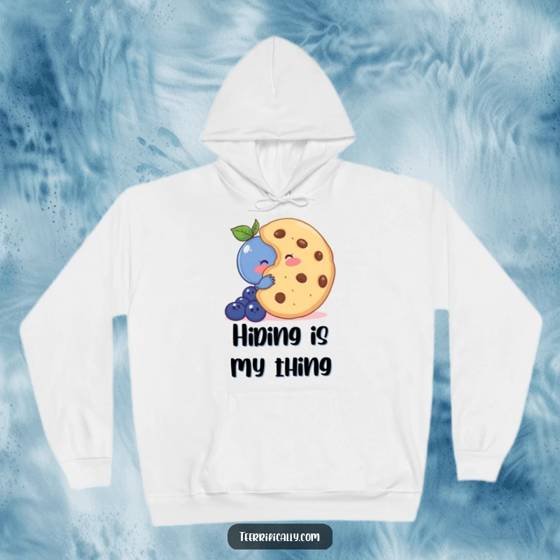 Funny hoodie showing a shy blueberry blushing behind a large cookie, embodying sweet innocence and comfort.