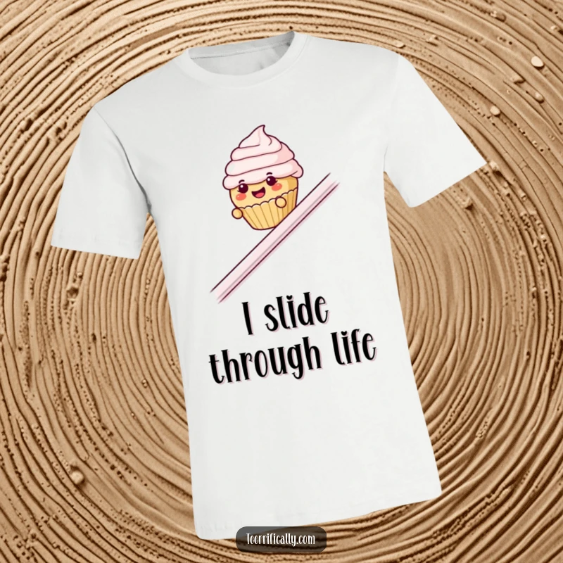 Funny cupcake banister t-shirt, depicting a small cupcake with eyebrows sliding down a railing with pure delight.